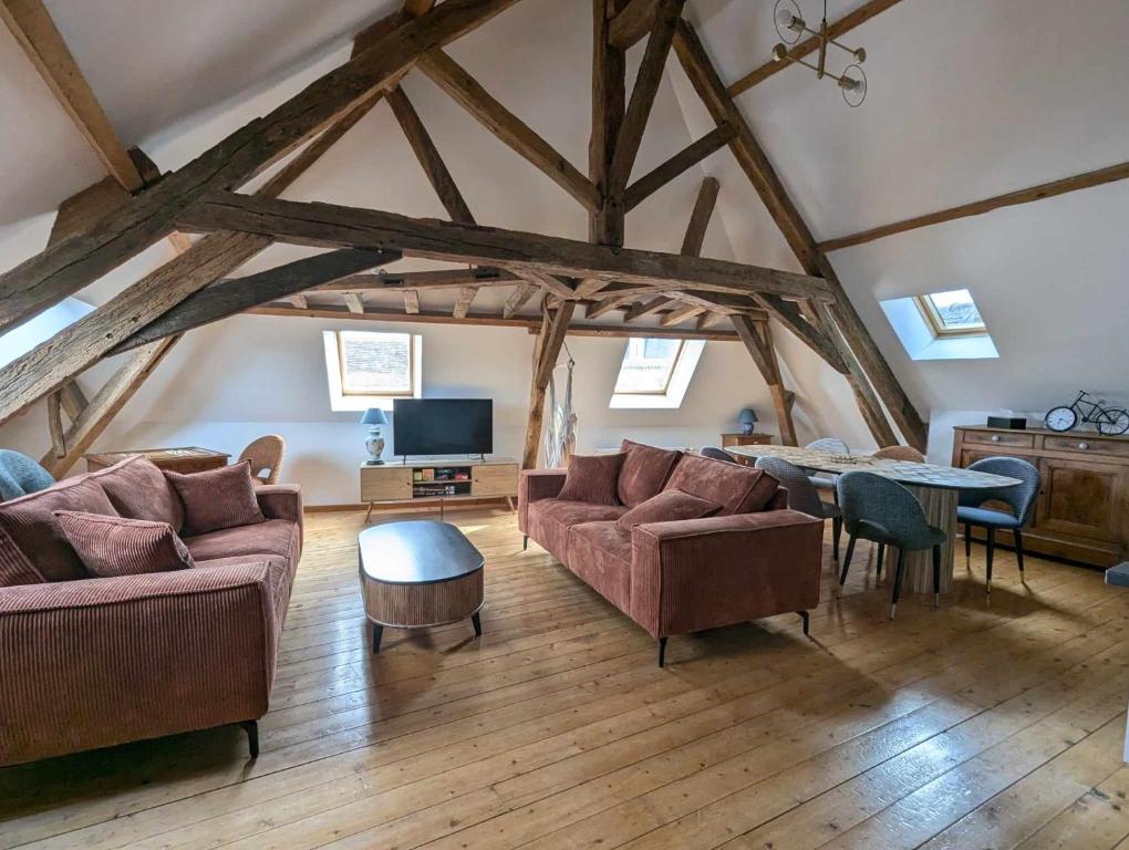 un salon avec deux canapés et une table dans l'établissement Appartement comble en centre ville de Bellême, à Bellême