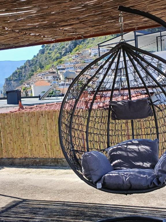 a hanging hammock with blue pillows on a balcony at Jemin Apartment in Berat