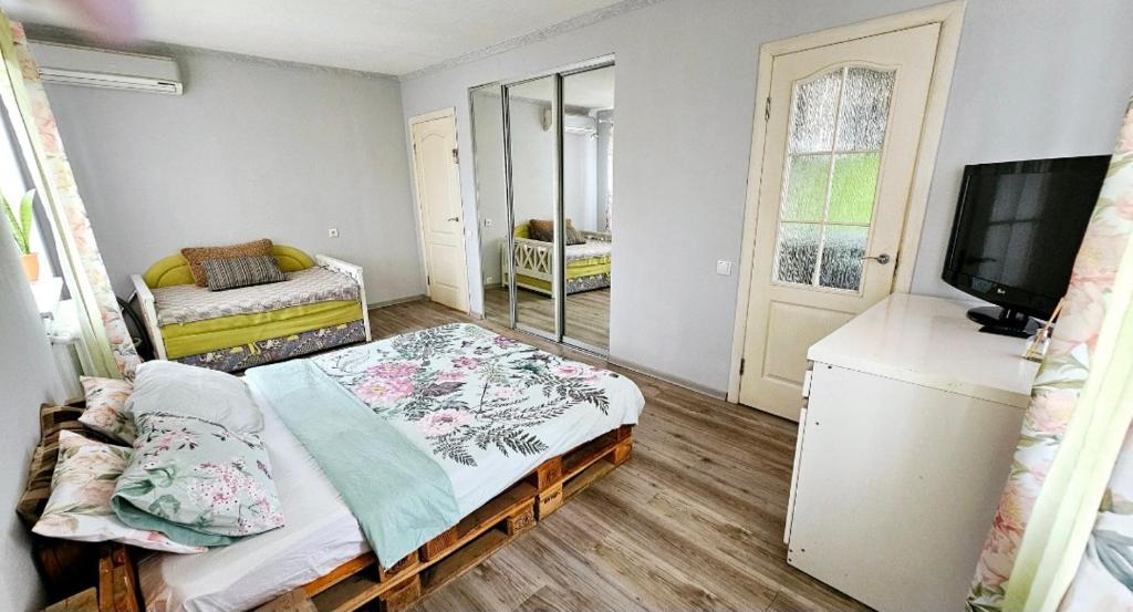 Kleines Zimmer mit einem Bett und einem TV. in der Unterkunft 1 комнатная квартира, левый берег, Пр Калнышевского, пр Слобожанский, 6 городская клиника in Nizhnedneprovsk