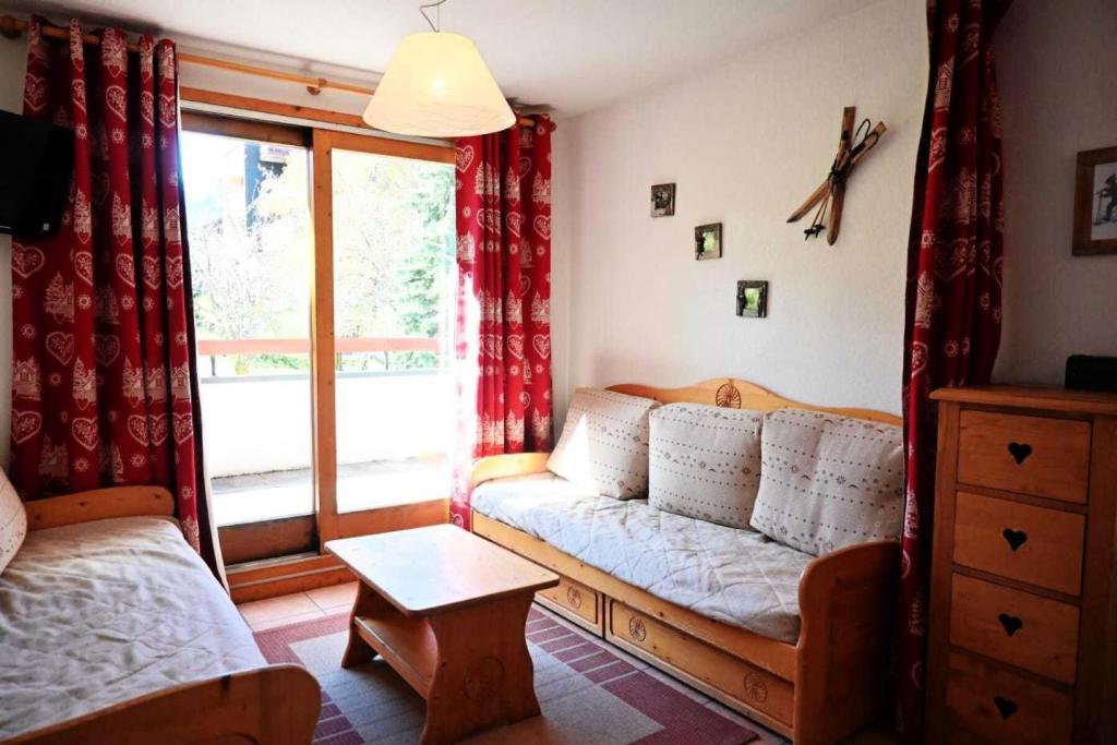 un salon avec un canapé et une fenêtre dans l'établissement Résidence Edelweiss - Appartement de charme 3 pièces 8 personnes à Vallandry proche des pistes, des commerces et du centre station MAE-2003, à Peisey-Nancroix