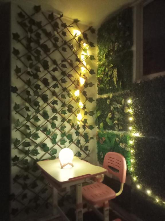 a table and a chair with lights on a wall at Apartamento Le petit prince in Paipa