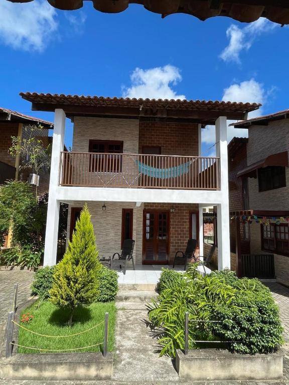 a house with a balcony on the front of it at Casa em condomínio - 8 pessoas - Gravatá-PE in Gravatá