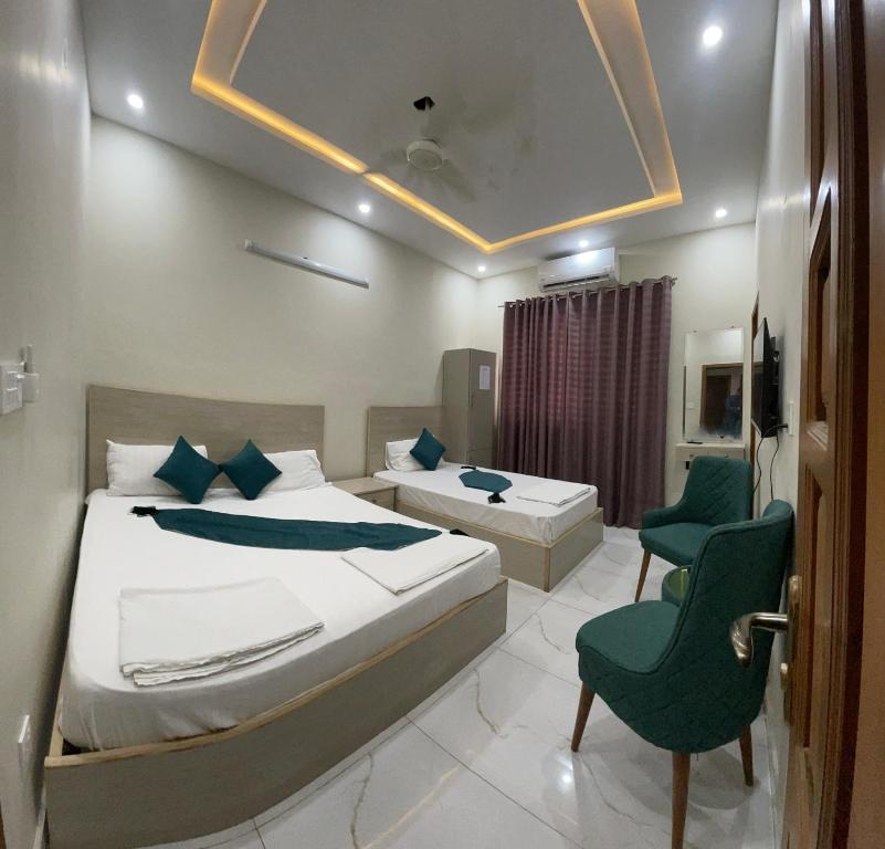 een hotelkamer met een bed en een stoel en een bed en een kamer bij Midways Guest House and Hotels in Islamabad