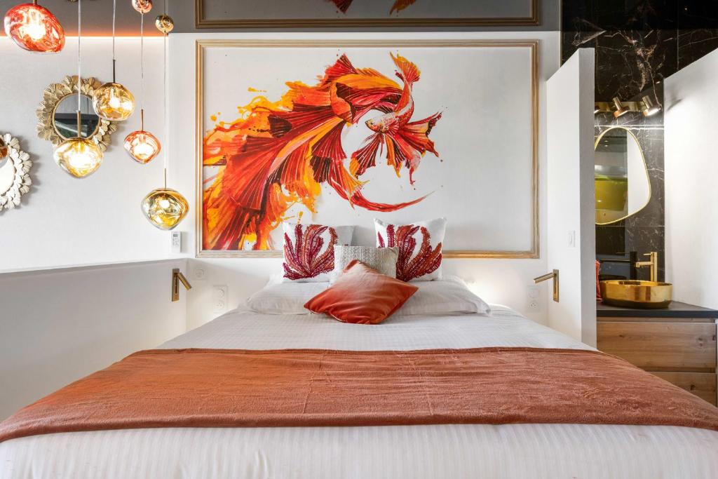 une chambre avec un lit avec un tableau sur le mur dans l'établissement Daïquiri - Héliopolis AB, au Cap d'Agde