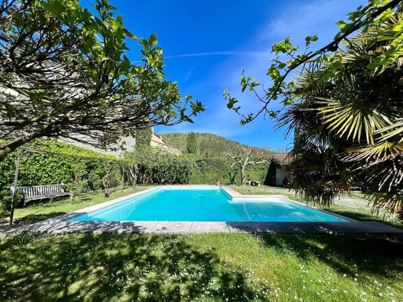 a blue swimming pool in a yard with trees at "La Verrerie haut" piscine, parking, proche du centre in Cahors