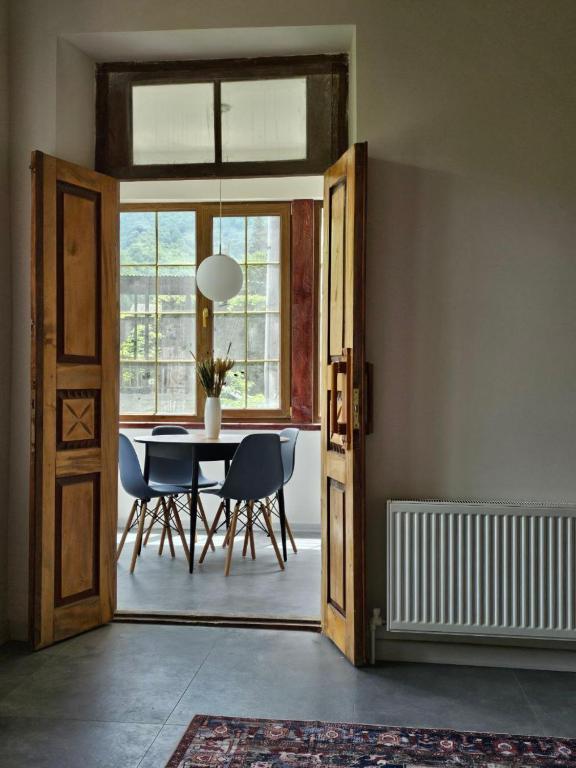 a dining room with a table and chairs and a window at Ponti House Dilijan - beautiful 2 bedroom house and separate 1 bed unit, sleeps 6 in Dilijan