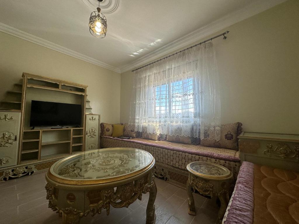 a living room with a table and a window at Appartement à Houma, proche Port Tanger Med in Dalia