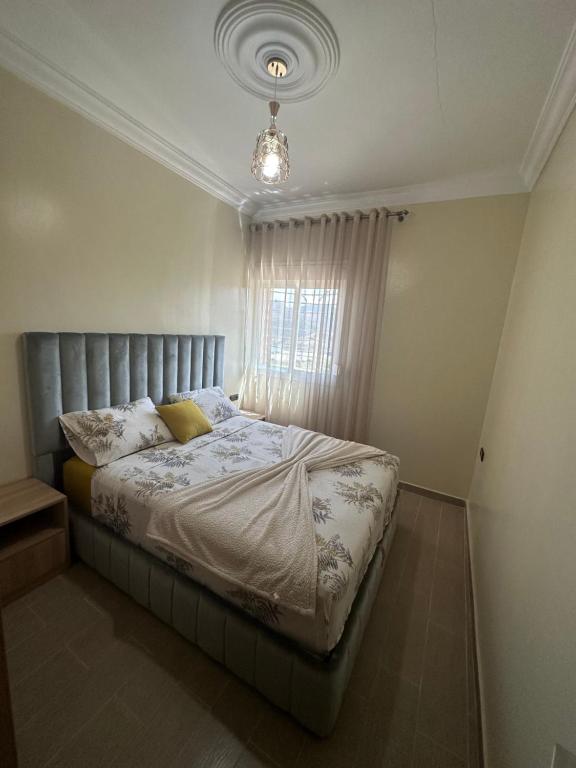 a bedroom with a bed with a silver headboard and a window at Appartement à Houma, proche Port Tanger Med in Dalia