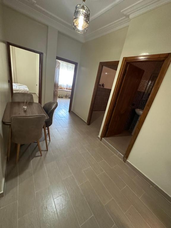 a living room with a table and chairs and a mirror at Appartement à Houma, proche Port Tanger Med in Dalia