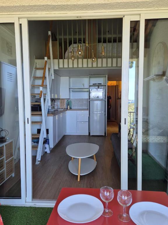 une cuisine et un salon avec une table et des chaises dans l'établissement Superbe vue mer 2pièces, mezzanine, clim 5 personnes, à Grimaud