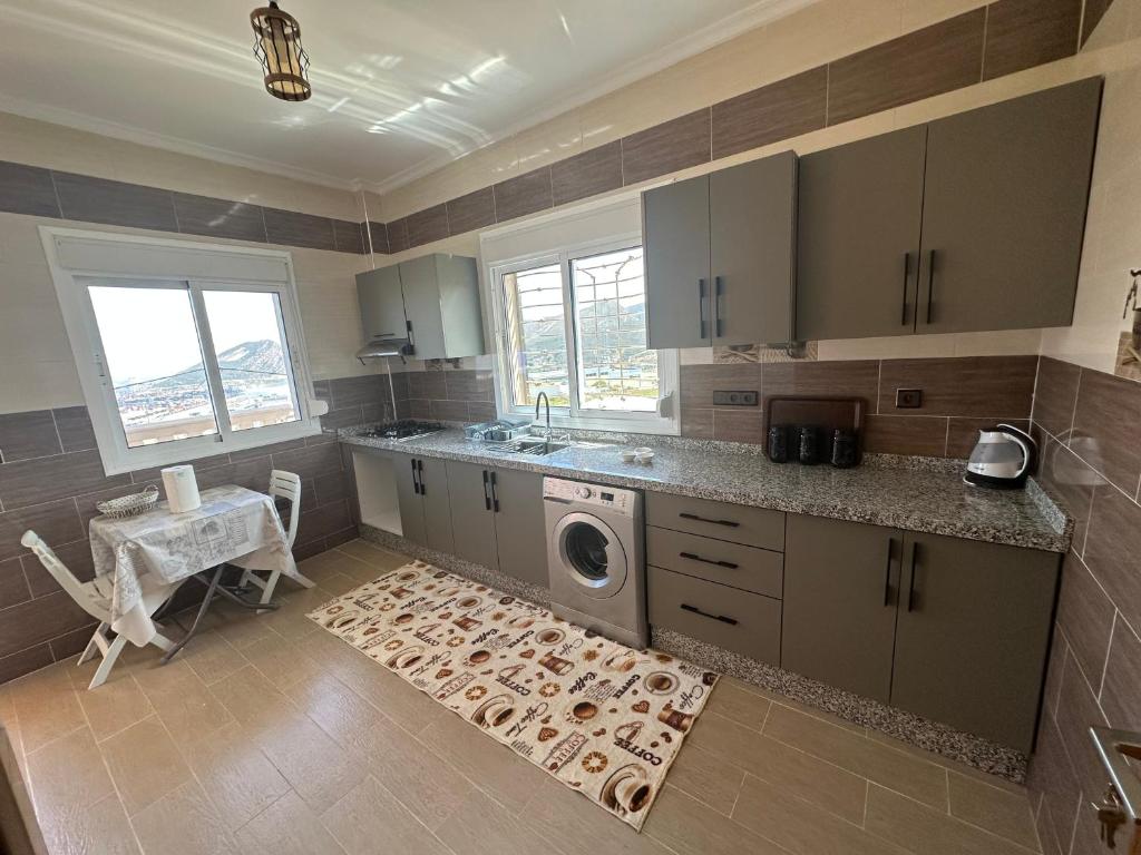 a kitchen with a sink and a washing machine at Appartement à Houma, proche Port Tanger Med in Dalia