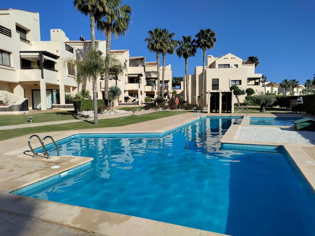 a swimming pool in front of some apartment buildings at Casa Colina Roda Golf in San Javier