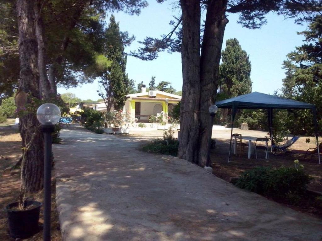 a driveway leading to a house with a tent and trees at Villetta Relax Salvamary in Porto Torres