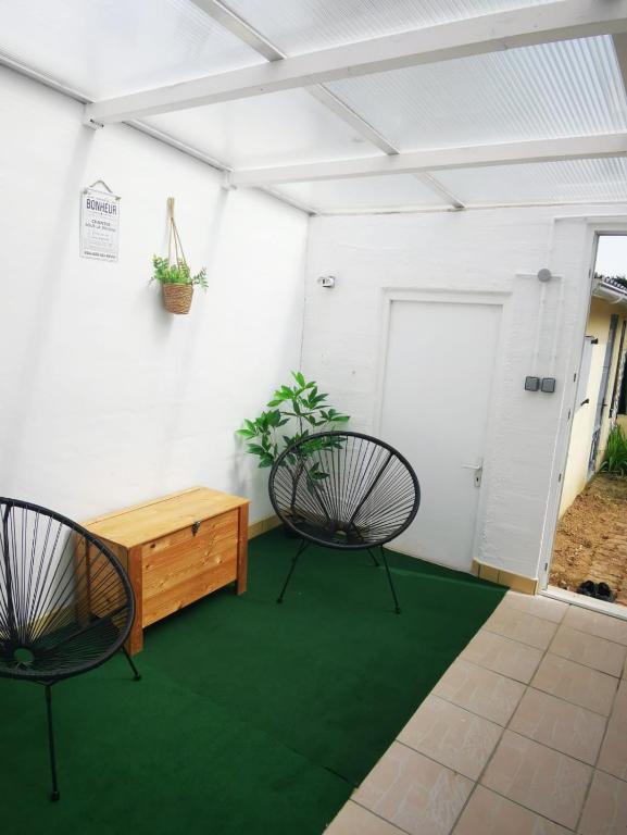 une chambre avec deux chaises et une table en bois dans l'établissement Votre cocon à 1km de la plage, à Camiers