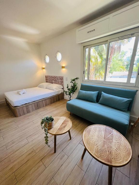 un salon avec un canapé et un lit dans l'établissement Seaside Studio with Terrace and Free Parking - Beach 2 Min Walk, à Villeneuve-Loubet