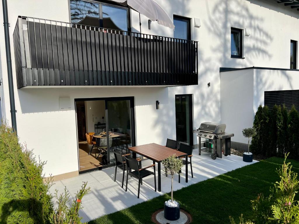 a patio with a table and a grill at Olea Prien - Chiemsee Apartment in Prien am Chiemsee