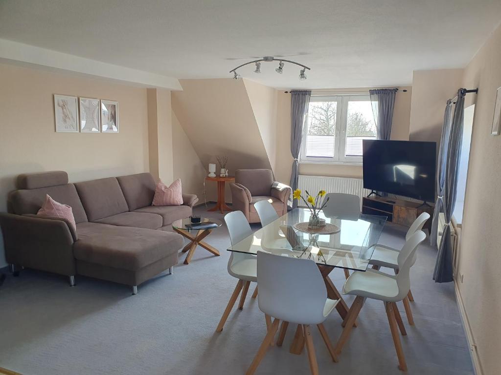 a living room with a couch and a glass table at Neumühler Hof- Ferienwohnung "Thomas" 3 Zimmer,3 Bäder mit Dusche, kostenfreie Parkplätze vor dem Haus in Schwerin