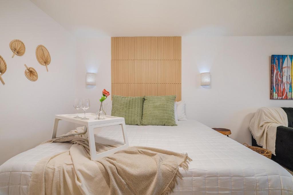 Un dormitorio con una cama blanca con una mesa y copas de vino. en Condado Ocean Front San Juan by PH, en San Juan