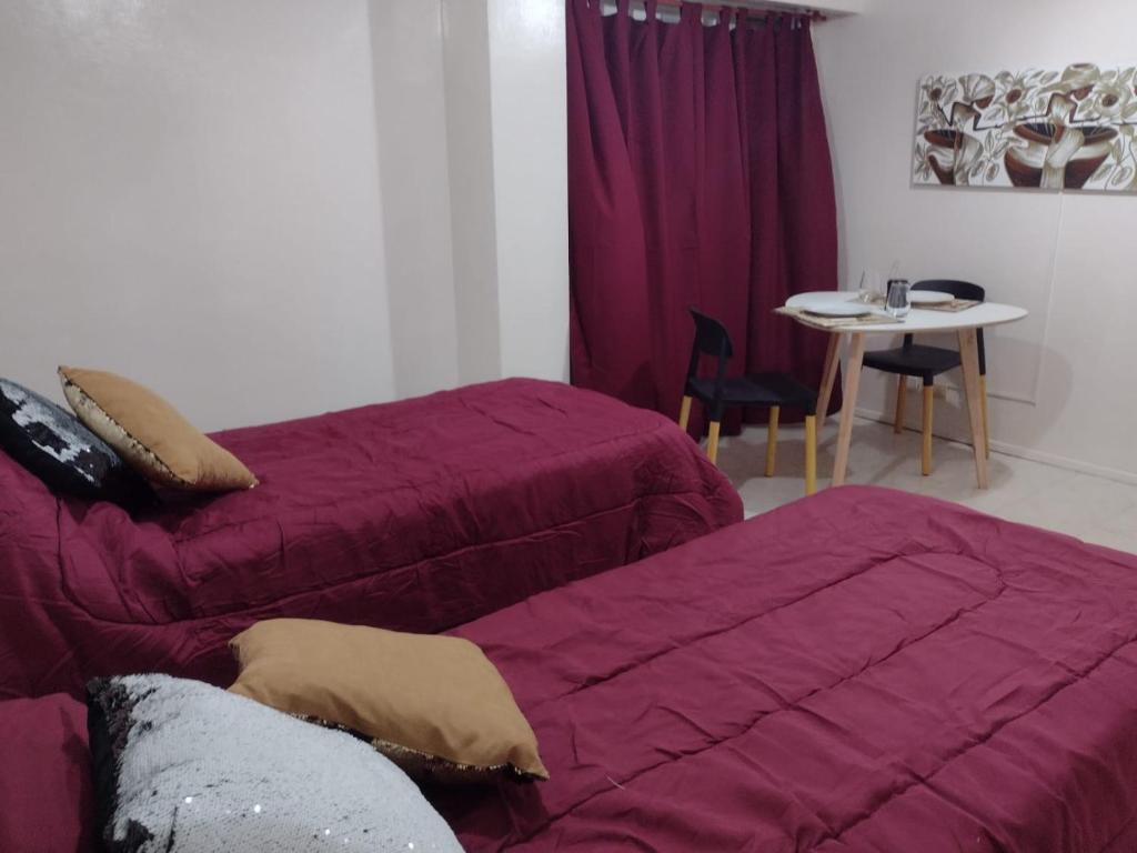Habitación de hotel con 2 camas y mesa con mesa en Obelisco full, en Buenos Aires