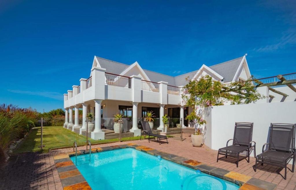 a house with a swimming pool in front of it at Wildehaven in St Francis Bay