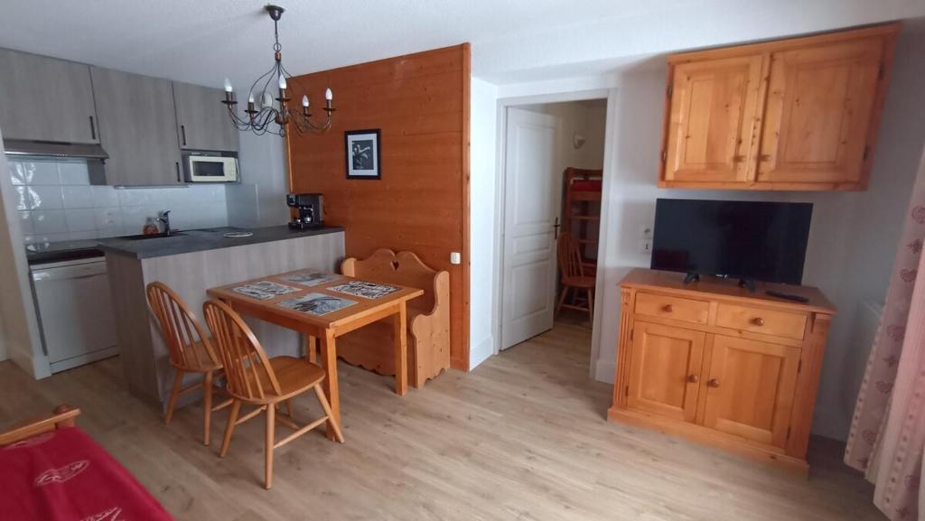 une petite cuisine avec une table et une télévision dans l'établissement Appartement 2 chambres au pied des pistes de l'espace Diamant, à Flumet