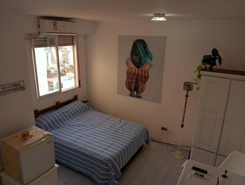 Un dormitorio con una cama y un cuadro en la pared. en El rincón de boedo, en Buenos Aires