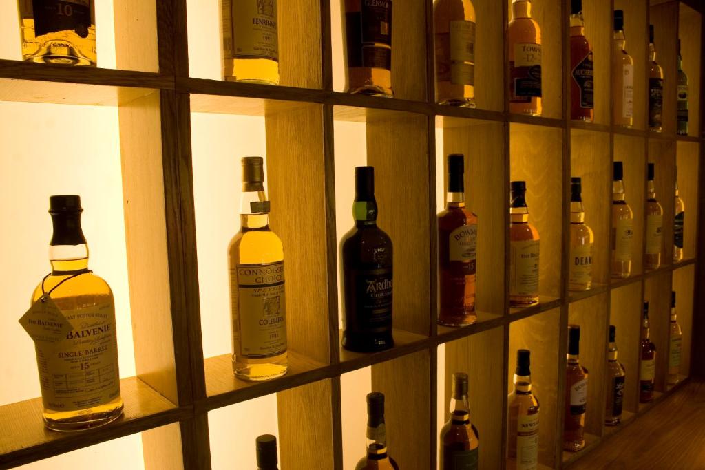 a shelf filled with lots of bottles of alcohol at The Inn on Loch Lomond in Luss