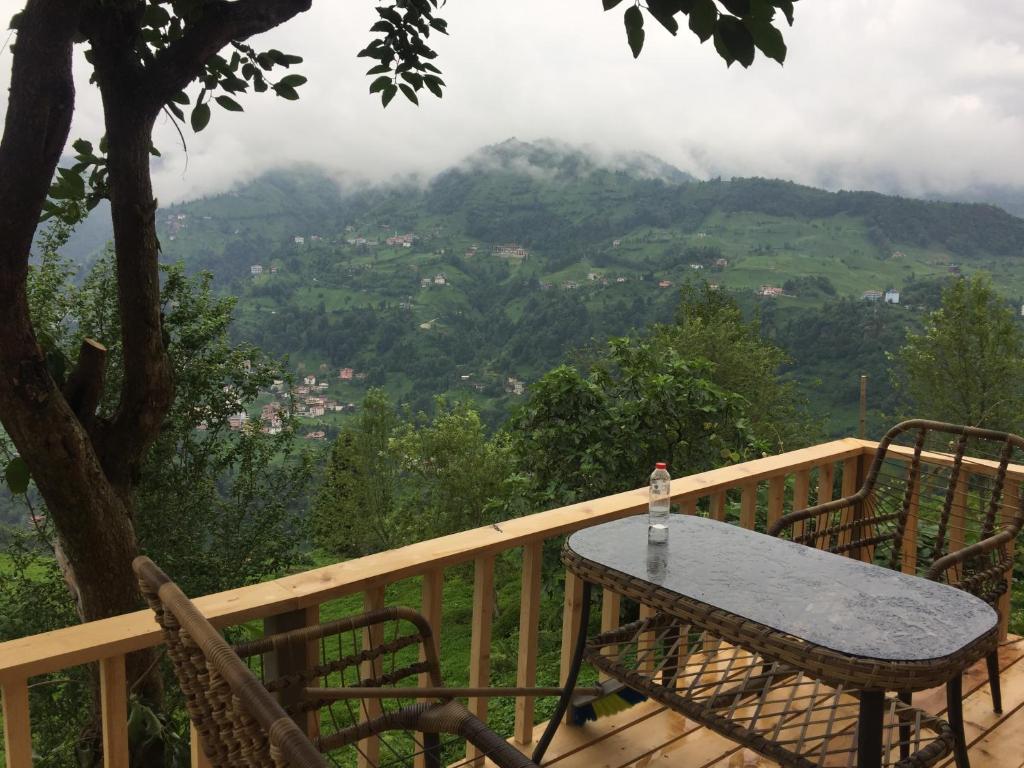 a table on a deck with a view of a mountain at Parla dağ evi kırmızı oda in Çamlıhemşin
