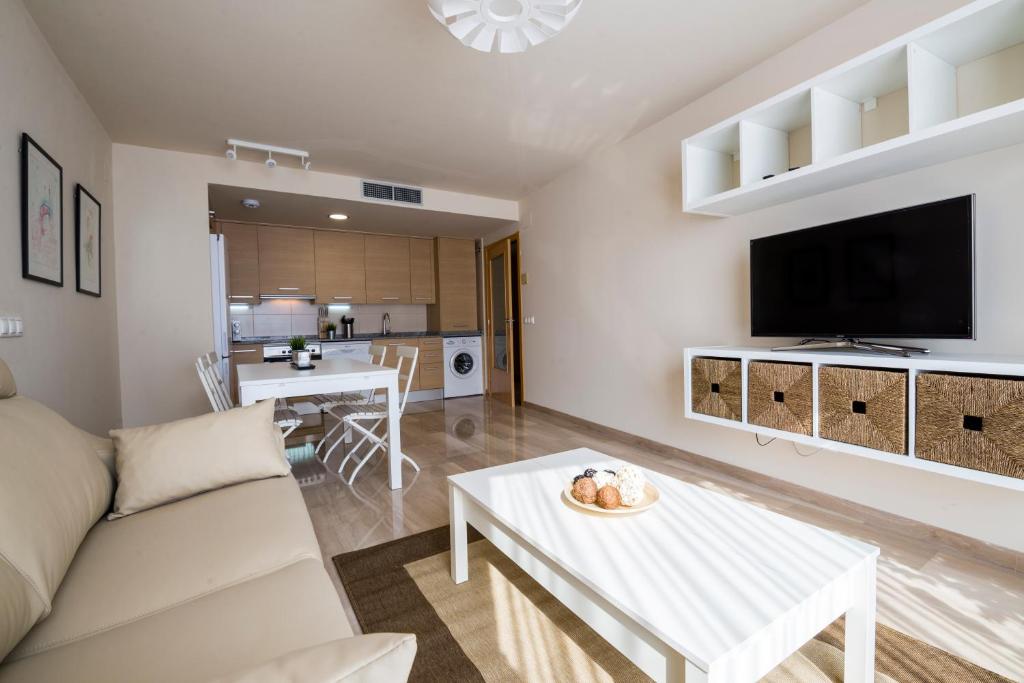 sala de estar con sofá y TV en Apartaments Peronel.la, en Lleida