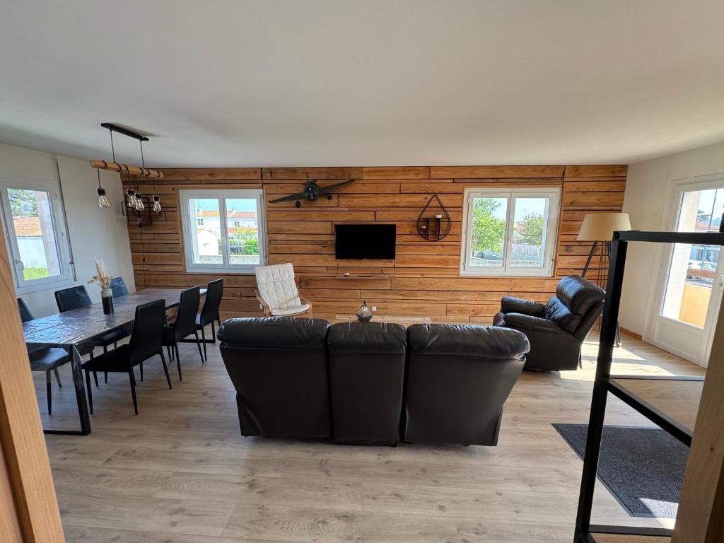 un salon avec un canapé et une salle à manger dans l'établissement Logement 6 couchages, 3 chambres , jardin , parking , fibre wifi, à Les Sables-dʼOlonne