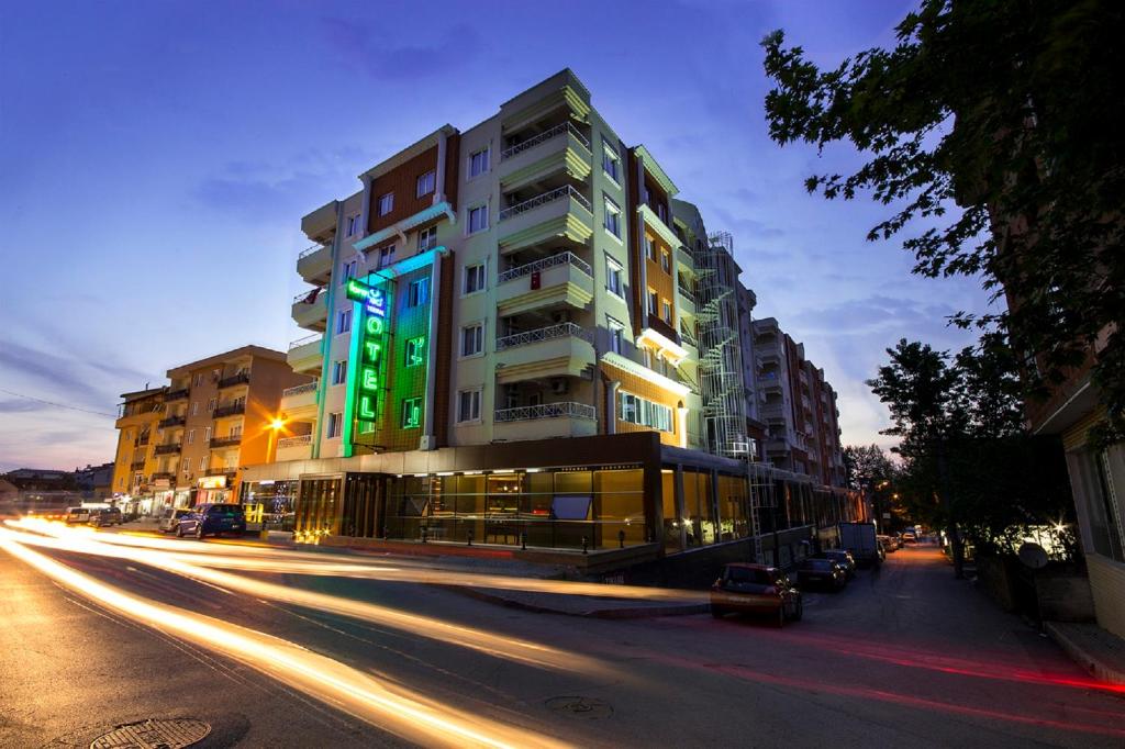 a tall building on a city street at night at Formback Thermal Suit & Apart in Bursa