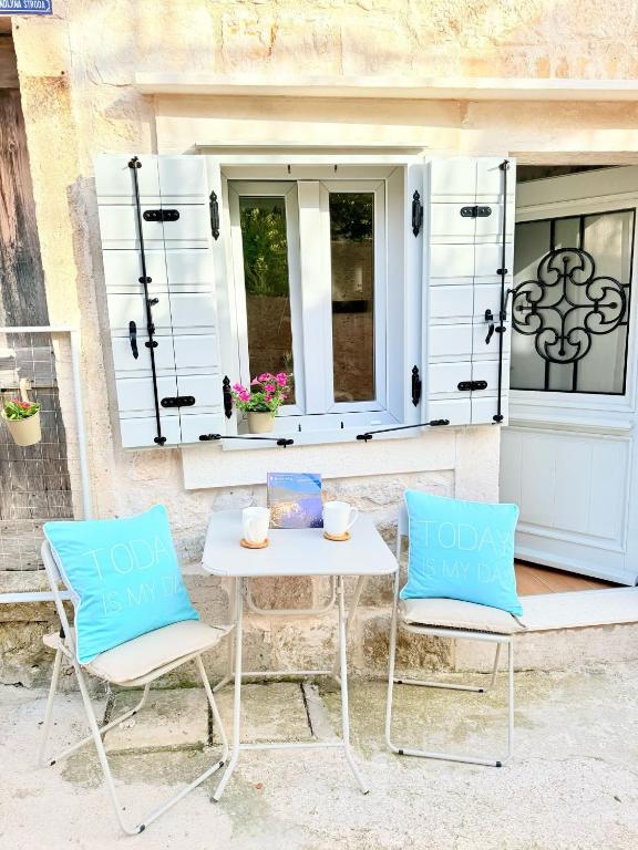 two chairs and a table in front of a window at Little House Komiza in Komiža