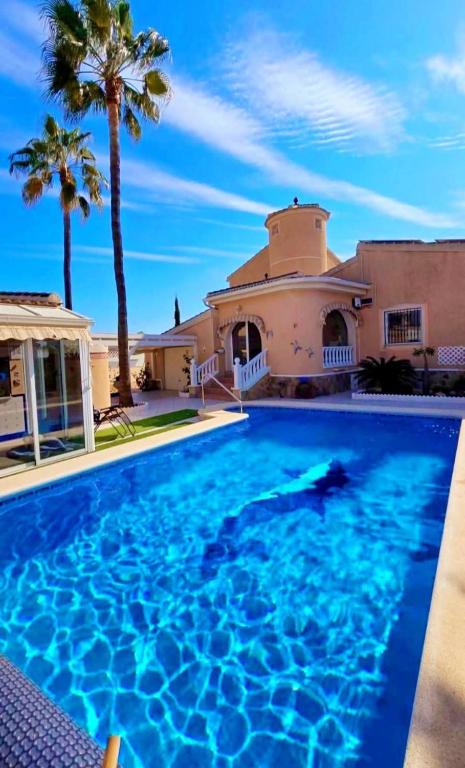 a large swimming pool in front of a house at Casa Valdi, fantastic 4 bedroom house with private,heated swimming pool and barbecue in Ciudad Quesada