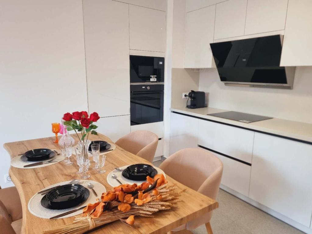 une cuisine avec une table en bois et des fleurs. dans l'établissement Appartement neuf et moderne à Puteaux, à Puteaux