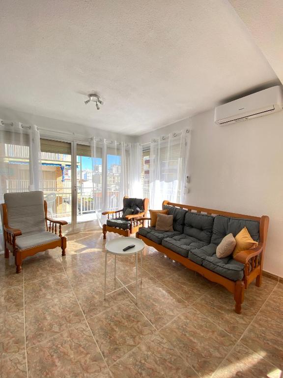 ein Wohnzimmer mit einer Couch und zwei Sesseln in der Unterkunft Balears Relax Apartment in Puerto de Gandía