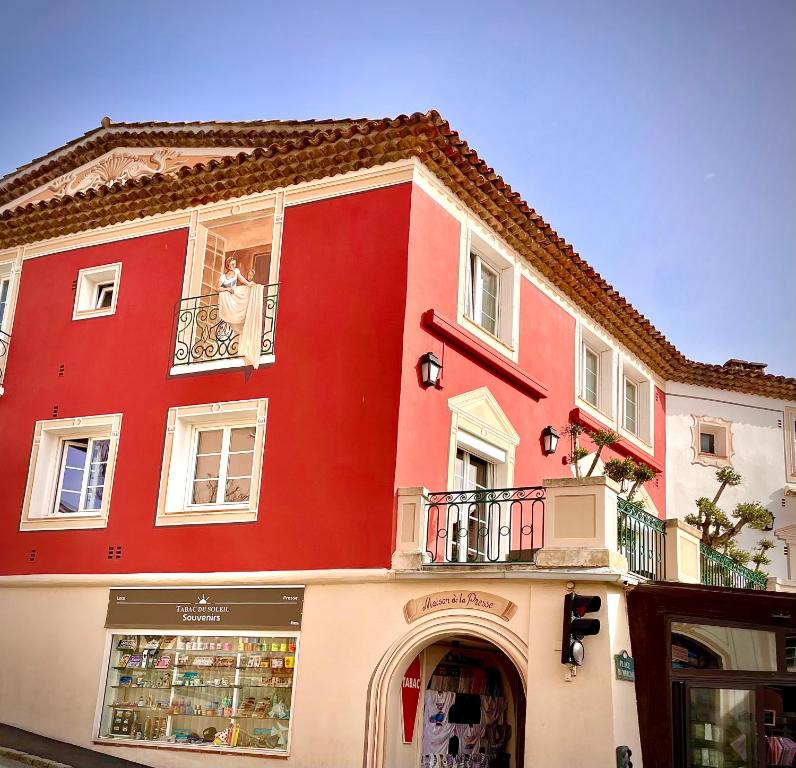 - un bâtiment rouge et blanc avec une fenêtre dans l'établissement Appartement les pieds dans l eau, à Grimaud