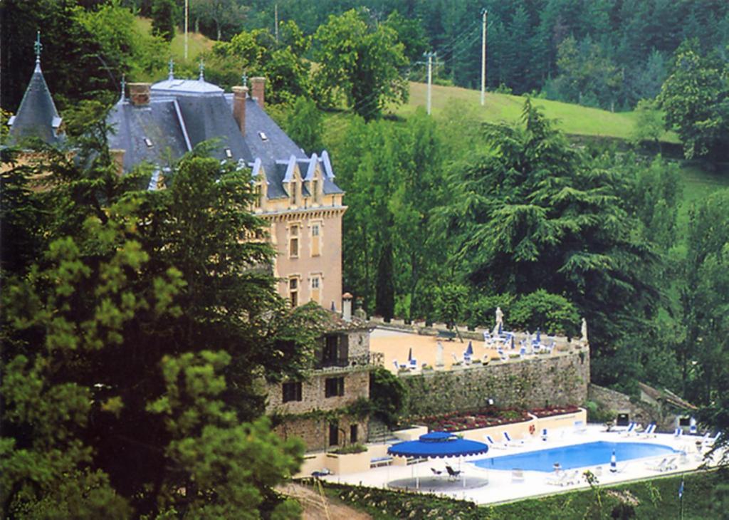 un grand château avec une piscine en face dans l'établissement Chateau d'Urbilhac, à Lamastre