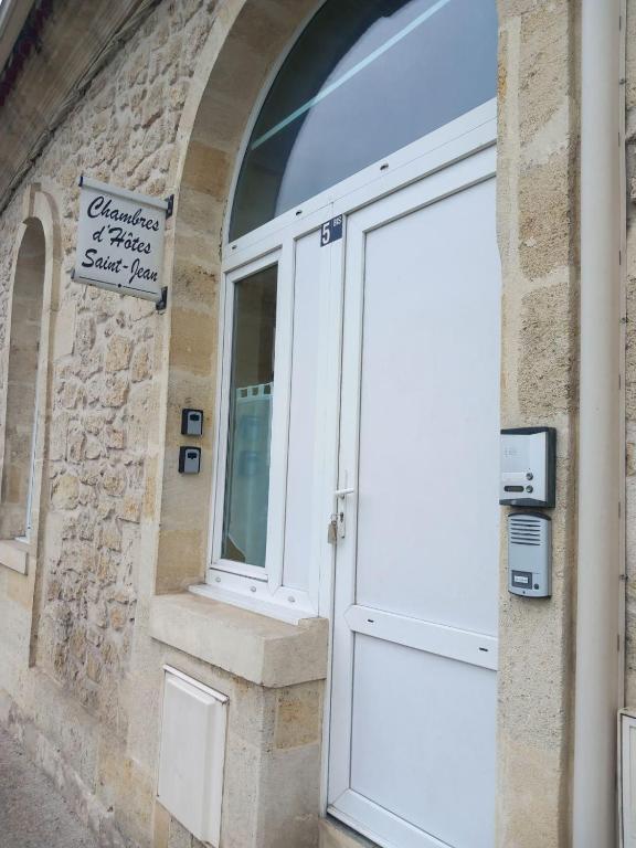 a white door on a building with a stone wall at Chambres D'Hôtes Saint Jean in Saint-Jean-de-Blaignac