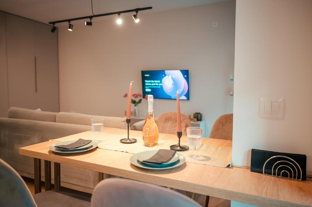 einen Esstisch mit Stühlen und einen TV in der Unterkunft Modern Apartment Atria Urban - North Bucharest, Sector 1 in Bukarest