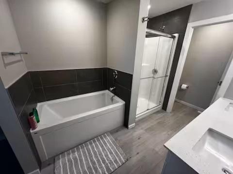 エドモントンにあるBrand New Bedroom with private bathroom in Keswickの浴槽、シャワー、洗面台を備えたバスルーム