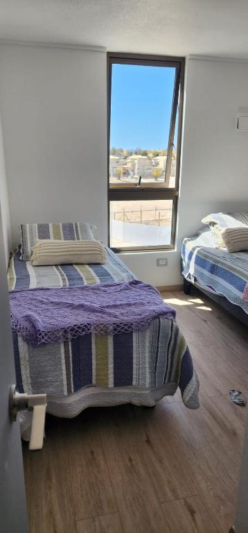 a bedroom with a bed and a window with a view at Steps to the beach, comfortable in Caldera
