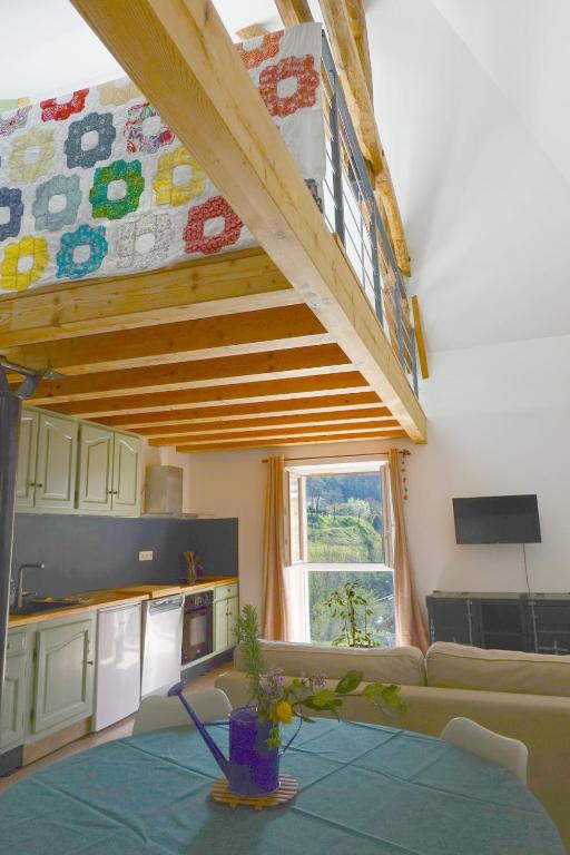 un salon avec une table et une cuisine dans l'établissement Un air de Finlande au pied de la dent du chat, à Saint-Jean-de-Chevelu