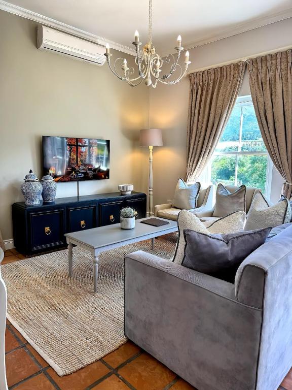 een woonkamer met een bank en een tafel bij Franschoek Lermitage Villa Two Bedroom Lake View in Franschhoek