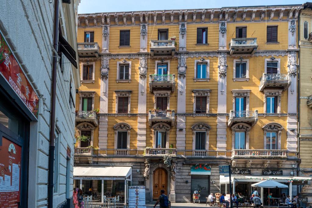 un grande edificio giallo con persone che camminano davanti di Next stop 5 Terre apartment a La Spezia