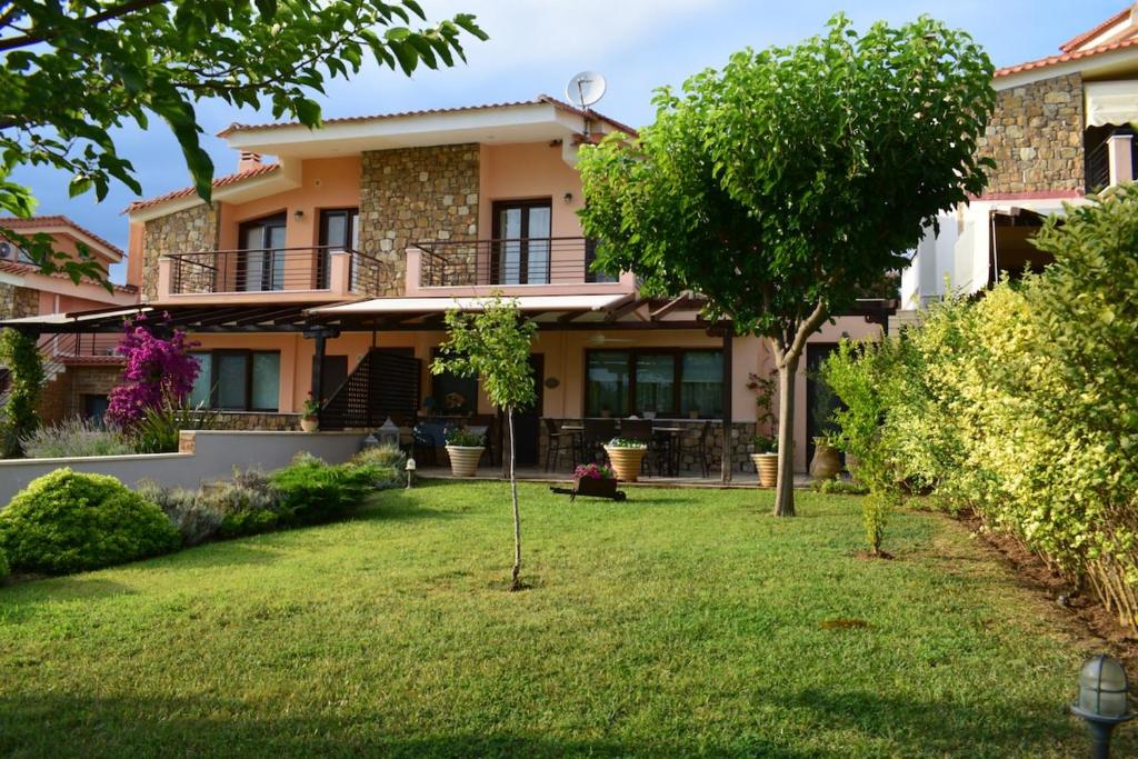 a house with a lawn in front of it at Oikia Kastri Sithon in Skála Nikíta