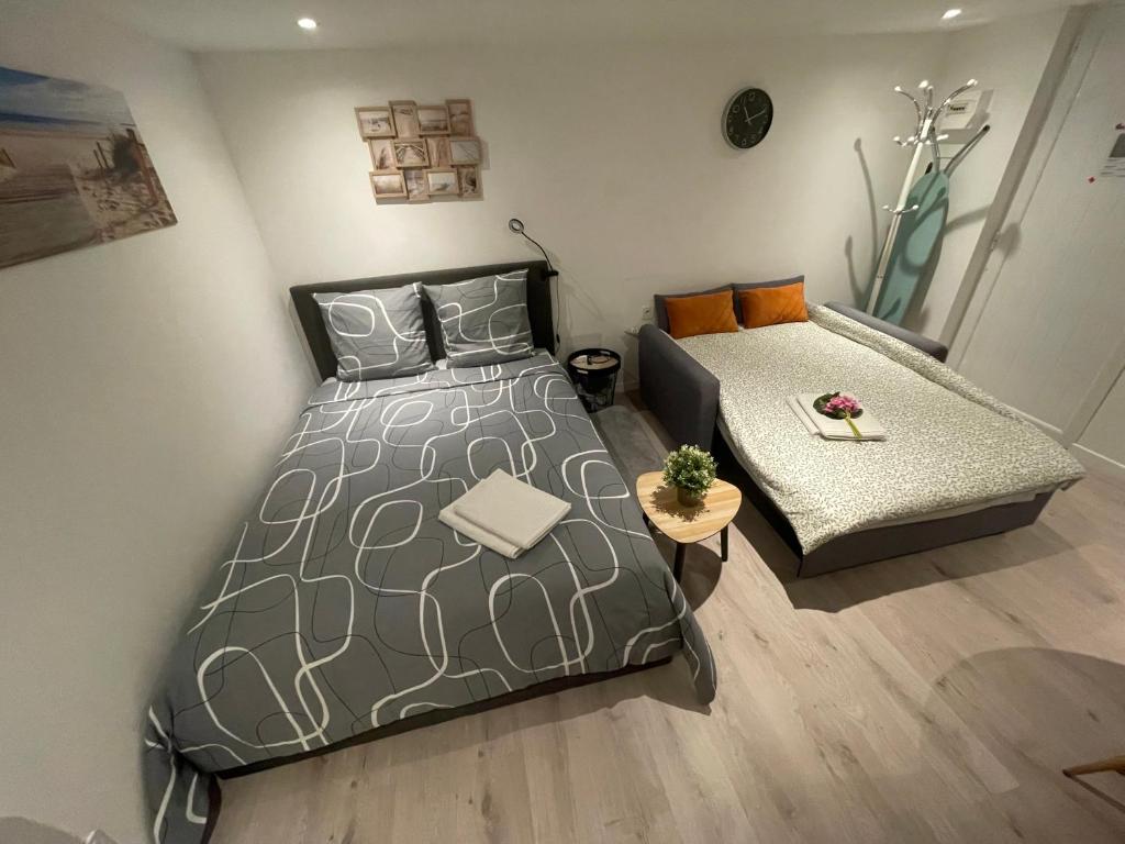 a bedroom with a bed and a couch at 'StudioCDG fr' Jardin, Studio proche near CDG Roissy airport, Parc Expositions, Stade de France, Arena, Disney, Asterix in Villepinte