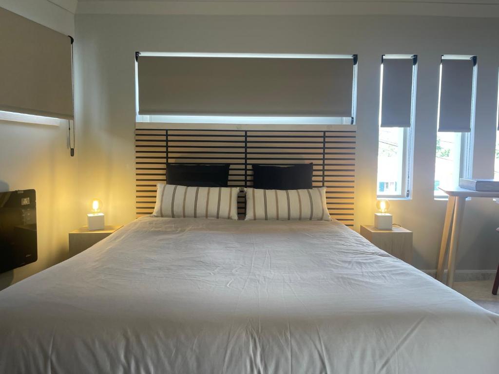 a bedroom with a large white bed with two lamps at BestHomeStay- Estoril in Estoril