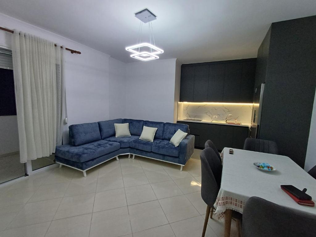 a living room with a blue couch and a table at 3 rooms apartment in vlora in Vlorë