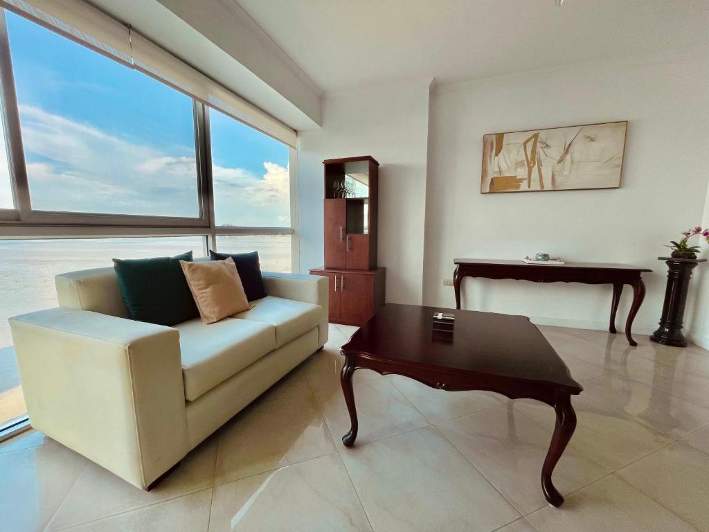 a living room with a white couch and a table at Suite frente al río en Puerto Santa Ana Riverfront in Guayaquil