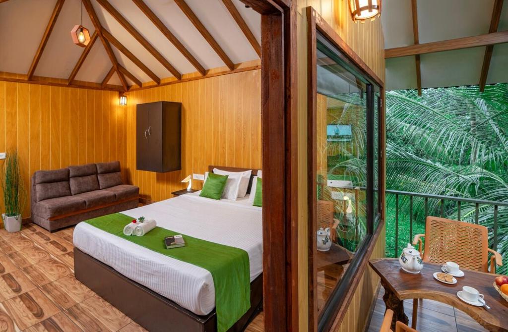 een slaapkamer met een bed en een bank in een kamer bij De Spicewoods, AC Cabin, Pool, Couple only in Kalpatta